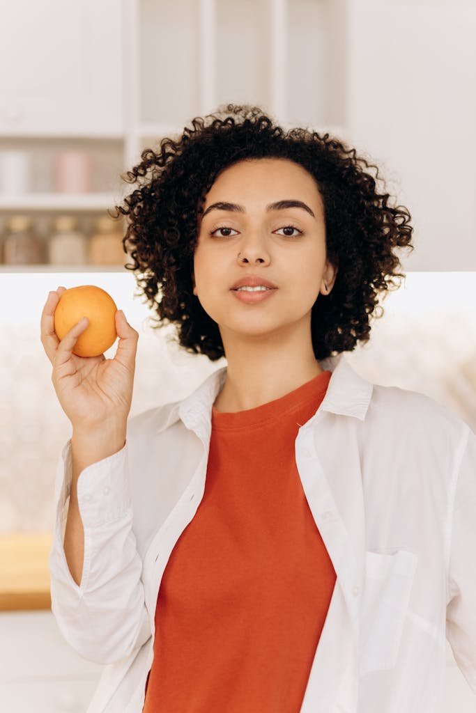 Girl in White Button Up Shirt Holding Orange Fruit